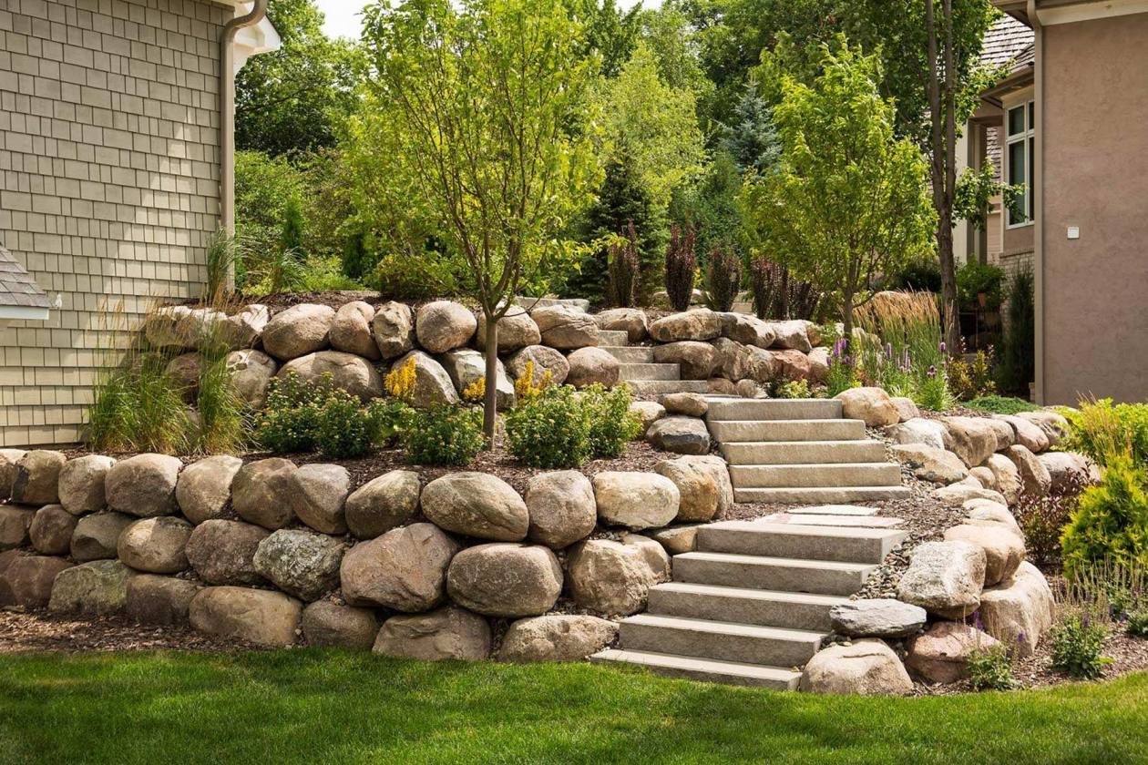 658f7c453bf50096abbf2088_homeguide-large-boulder-retaining-wall-with-steps-leading-to-house